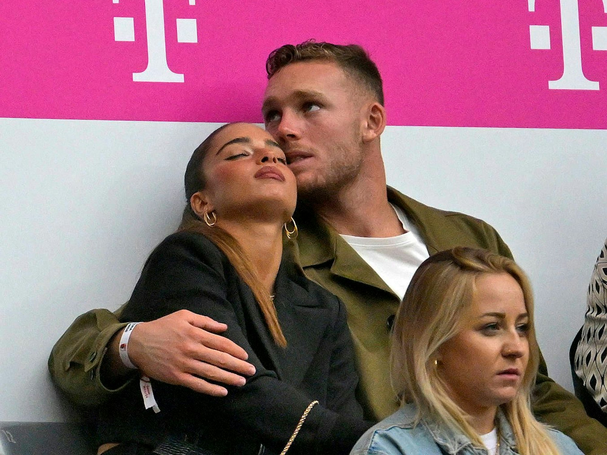 Bayern Münchens Daniel Peretz hat seine Freundin Noa Kirel im Arm. Sie sitzen auf der Tribüne der Allianz-Arena.