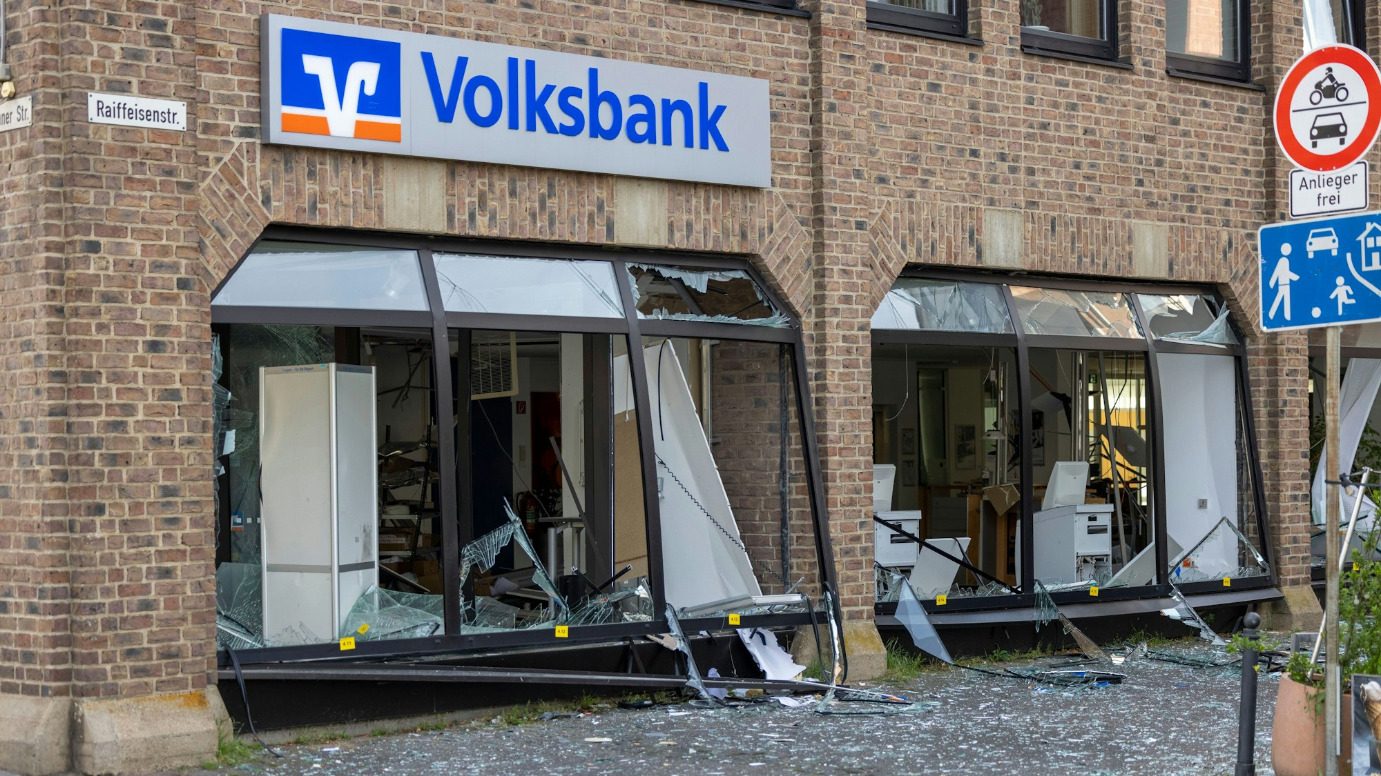 Die Glasfassade einer Bankfiliale ist schwer beschädigt, die Fläche davor ist mit Scherben übersät.