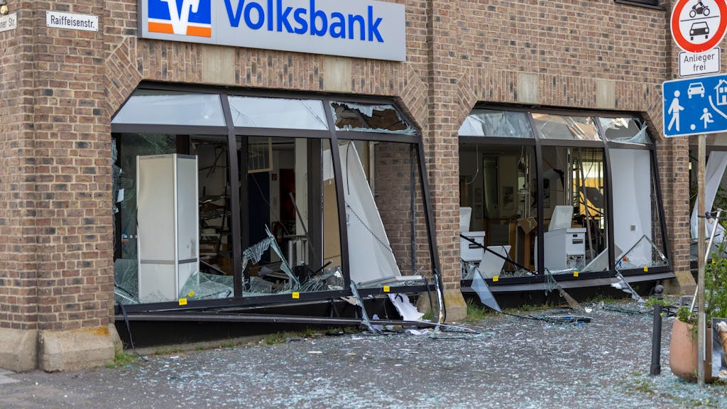 Die Glasfassade einer Bankfiliale ist schwer beschädigt, die Fläche davor ist mit Scherben übersät.&nbsp;