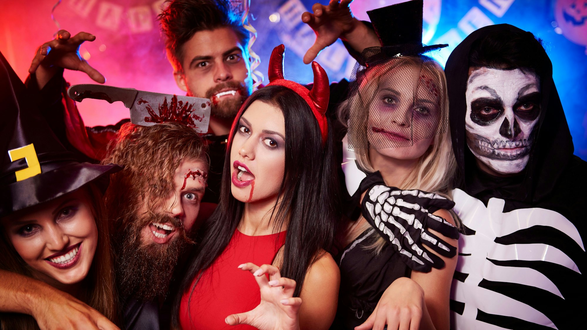 Halloween-Feiernde sind als Teufel, Hexe, Skelett und Werwolf verkleidet.