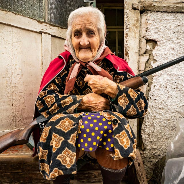 Eine alte Frau sitzt mit einem Gewehr im Eingang ihres Hauses, während die aserbaidschanische Armee die Stadt Stepanakert unter Beschuss nimmt.