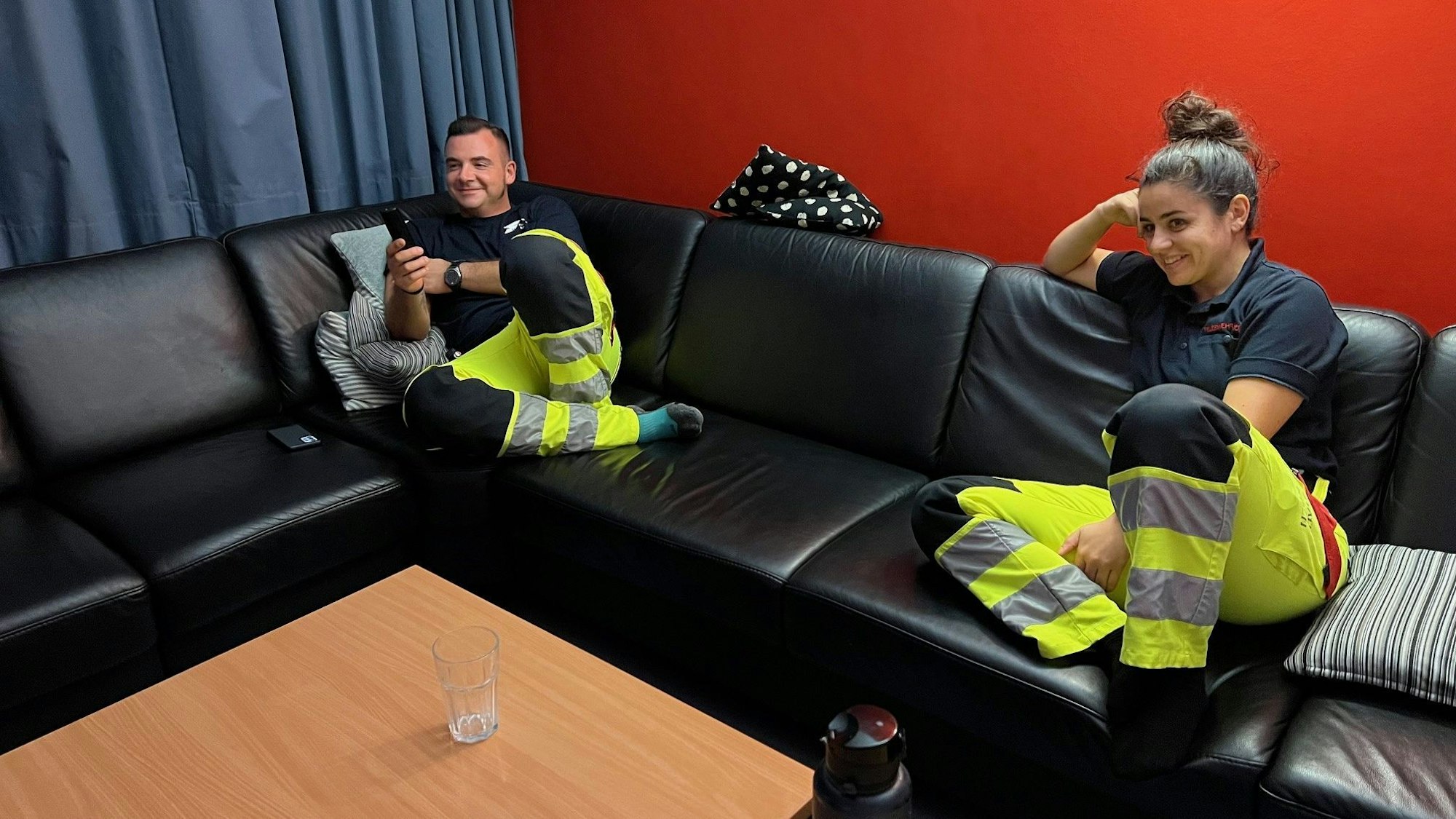 Markus Buth und Veronika Capoccia sitzen im Fernsehraum der Feuerwache 4 auf einem Sofa.