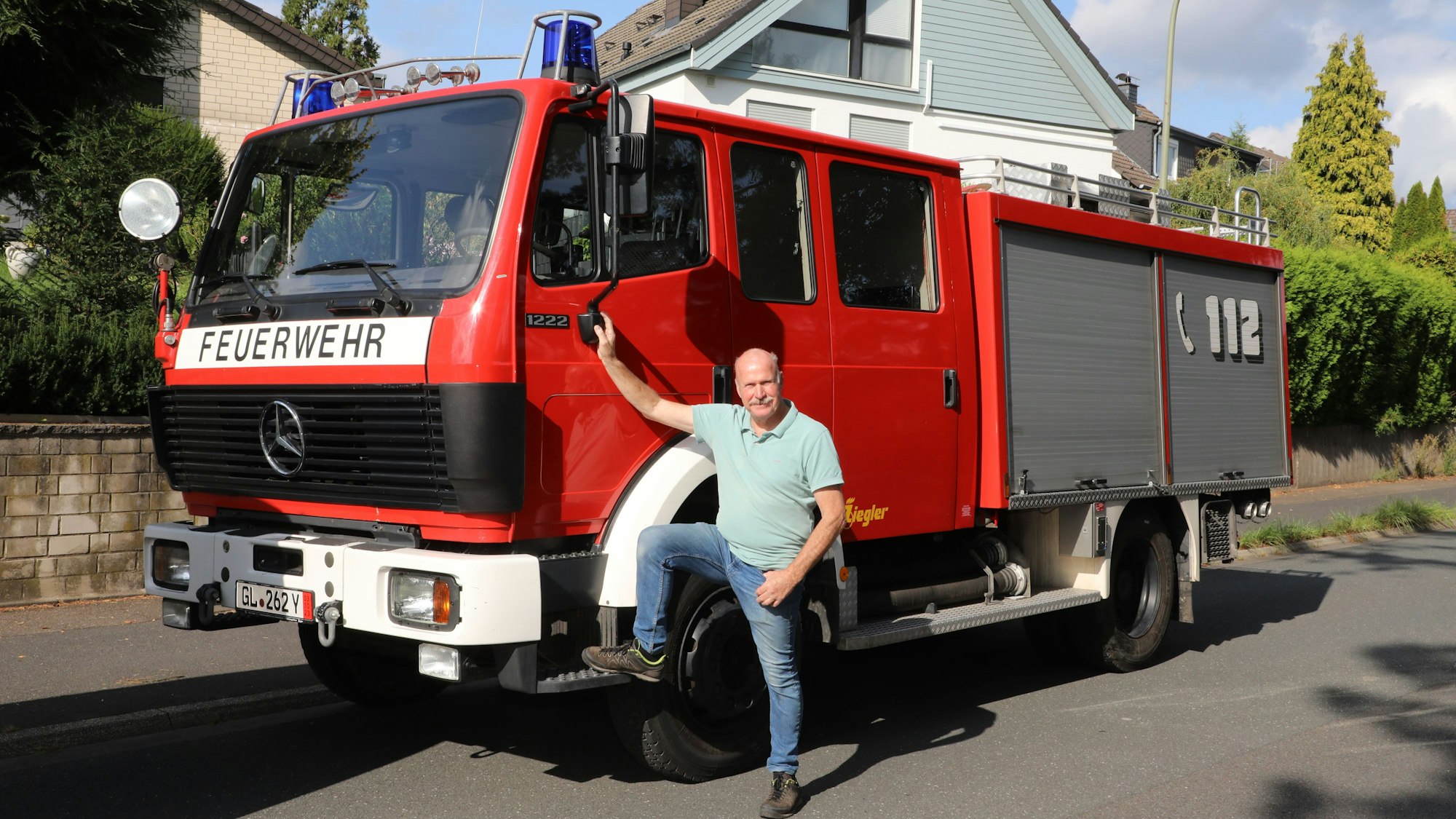 Ein Mann steht an einem Feuerwehrfahrzeug.