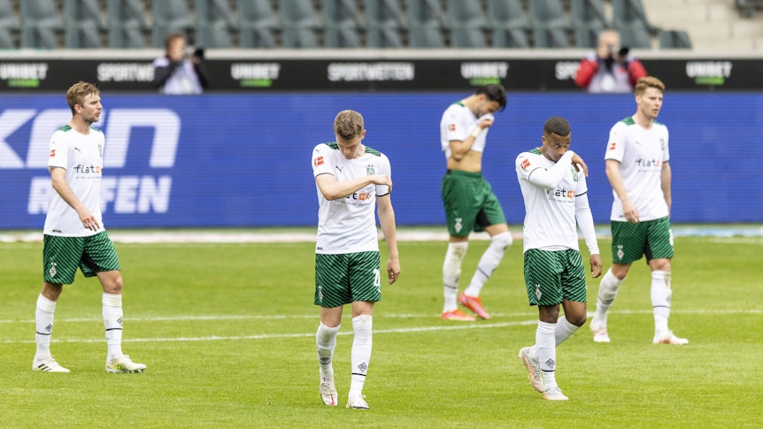 Spieler von Borussia Mönchengladbach verlassen enttäuscht das Spielfeld.