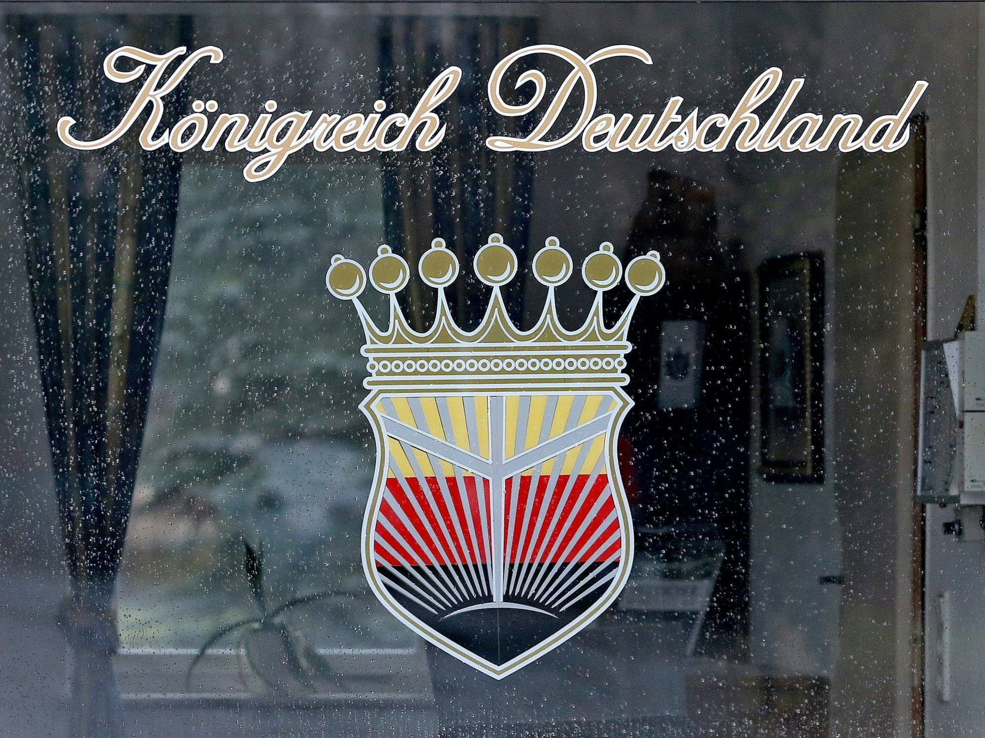 Das Logo des „Königreich Deutschland“ prangt am Fenster eines Pförtnerhauses in Wittenberg (Sachsen-Anhalt).