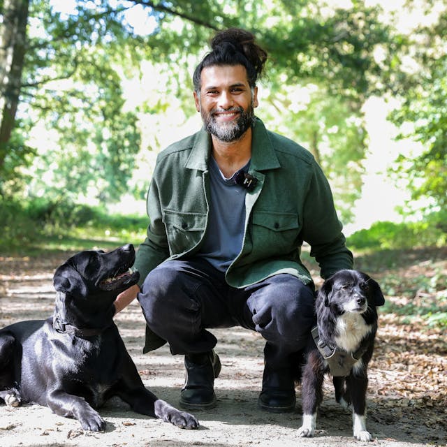 Hunde-Verhaltenstherapeut Masih Samin mit zwei Hunden auf einem Waldweg.&nbsp;