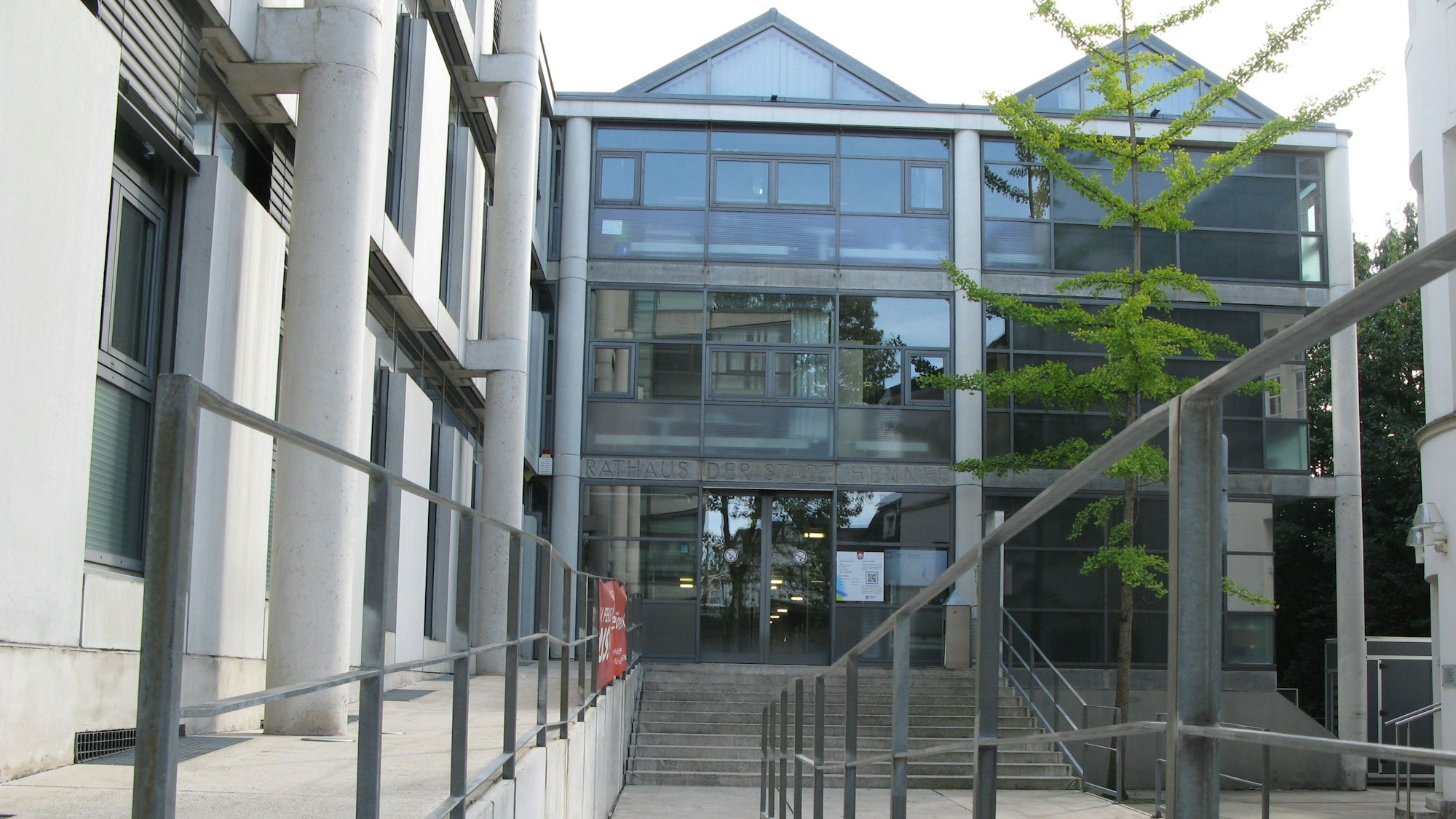 Das Bild zeigt den Eingang des Hennefer Rathauses mit Treppe und Rampe.