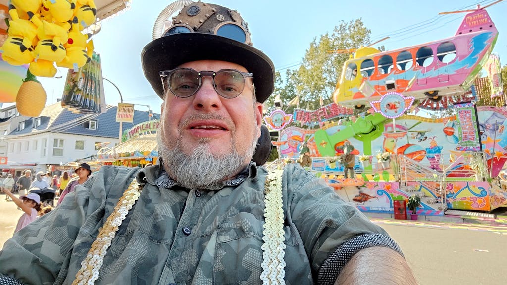 Rollstuhlfahrer Dirk Kolfhaus macht ein Selfie auf einer Kirmes.