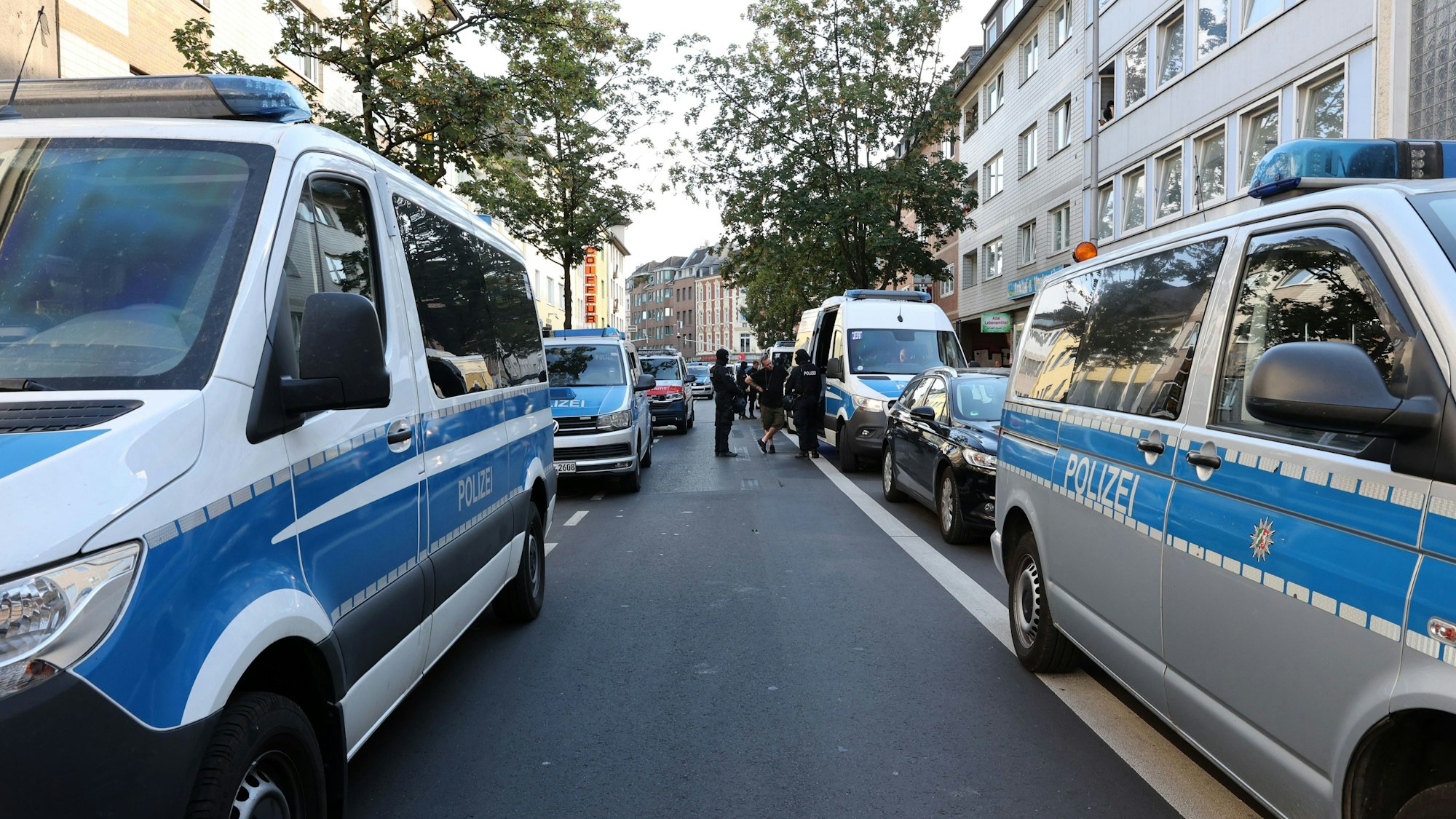 Mehrere Polizeifahrzeuge stehen in einer Straße in Köln-Kalk.
