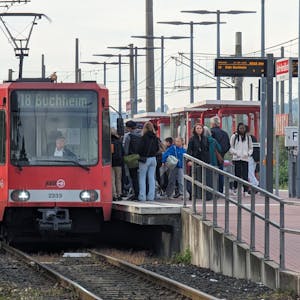 Eine Straßenbahn steht am bevölkerten Bahnsteig in Hermülheim.