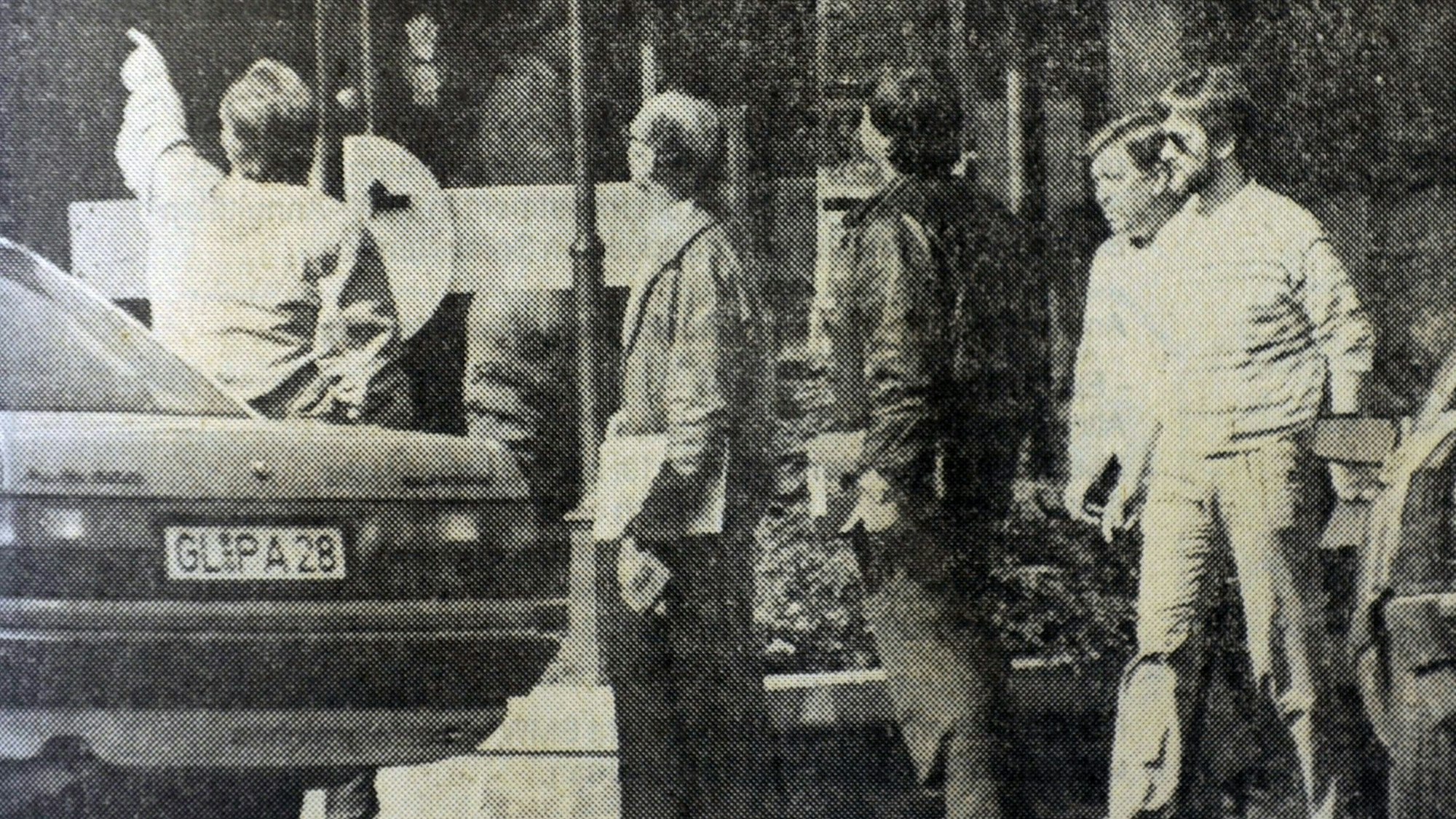 Männer in Kleidung der 80er Jahre. Ein altes Foto in Schwarz-Weiß aus einer Zeitung.