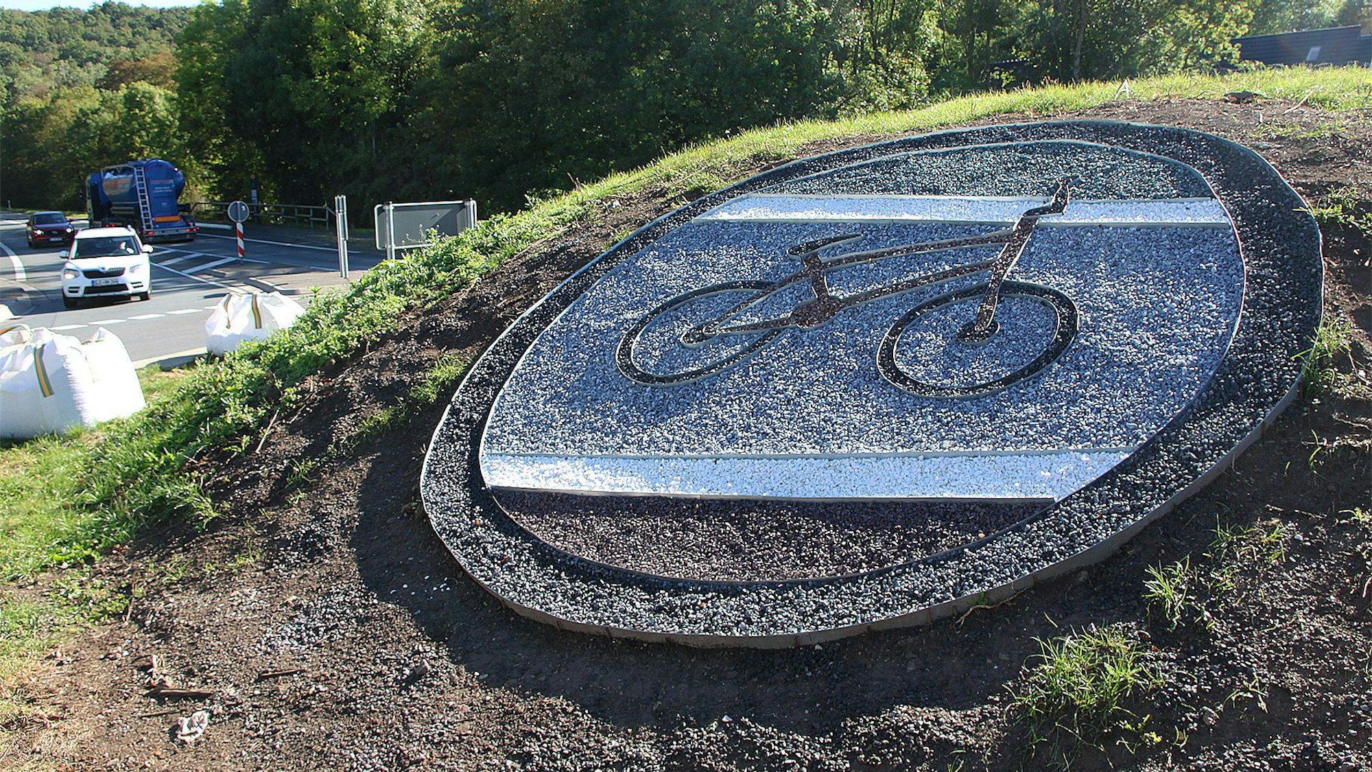 Mit einem Fahrrad wird auf der Insel des Kreisverkehrs in Ahrhütte der Aktionstag Tour de Ahrtal dargestellt.