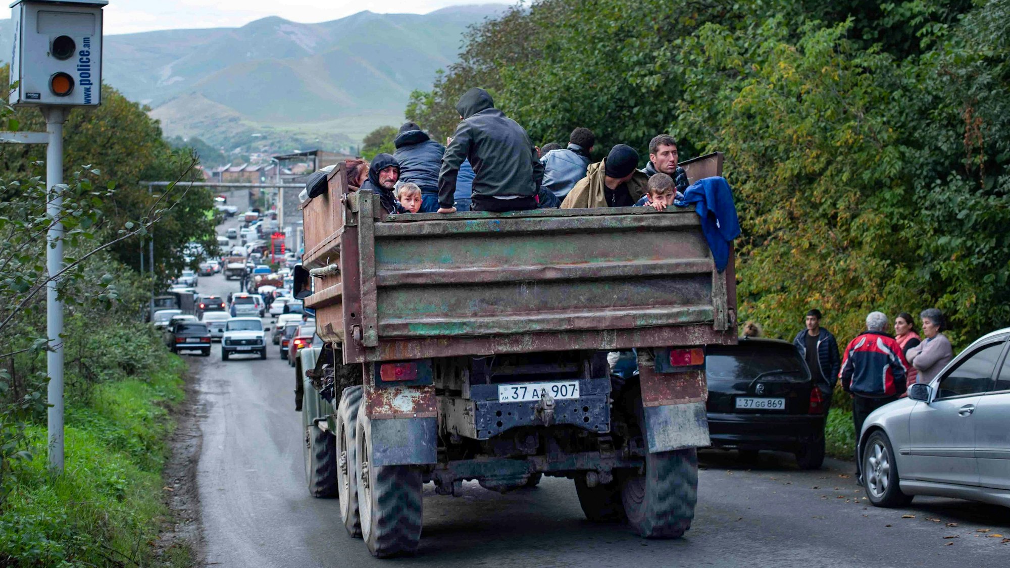 26.09.2023, Aserbaidschan, Goris: Ethnische Armenier aus Berg-Karabach sitzen in einem Lastwagen auf dem Weg nach Goris in der Region Syunik. Nach der Eroberung des Gebietes Berg-Karabach durch Aserbaidschan wächst die Zahl der nach Armenien flüchtenden Menschen . Foto: Gayane Yenokyan/AP/dpa +++ dpa-Bildfunk +++
