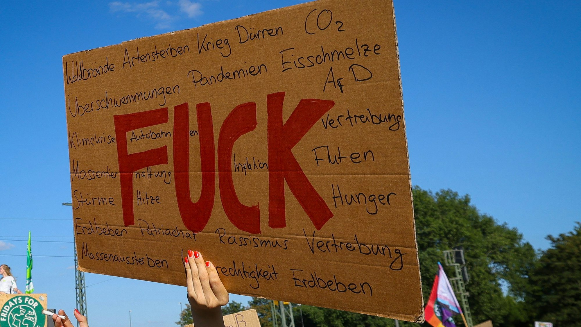 Eine junge Frau hält ein Pappschild mit der Aufschrift „Fuck“ bei einem Protestzug der Klimaschutzbewegung Fridays for Future durch die Innenstadt.(Symbolbild)