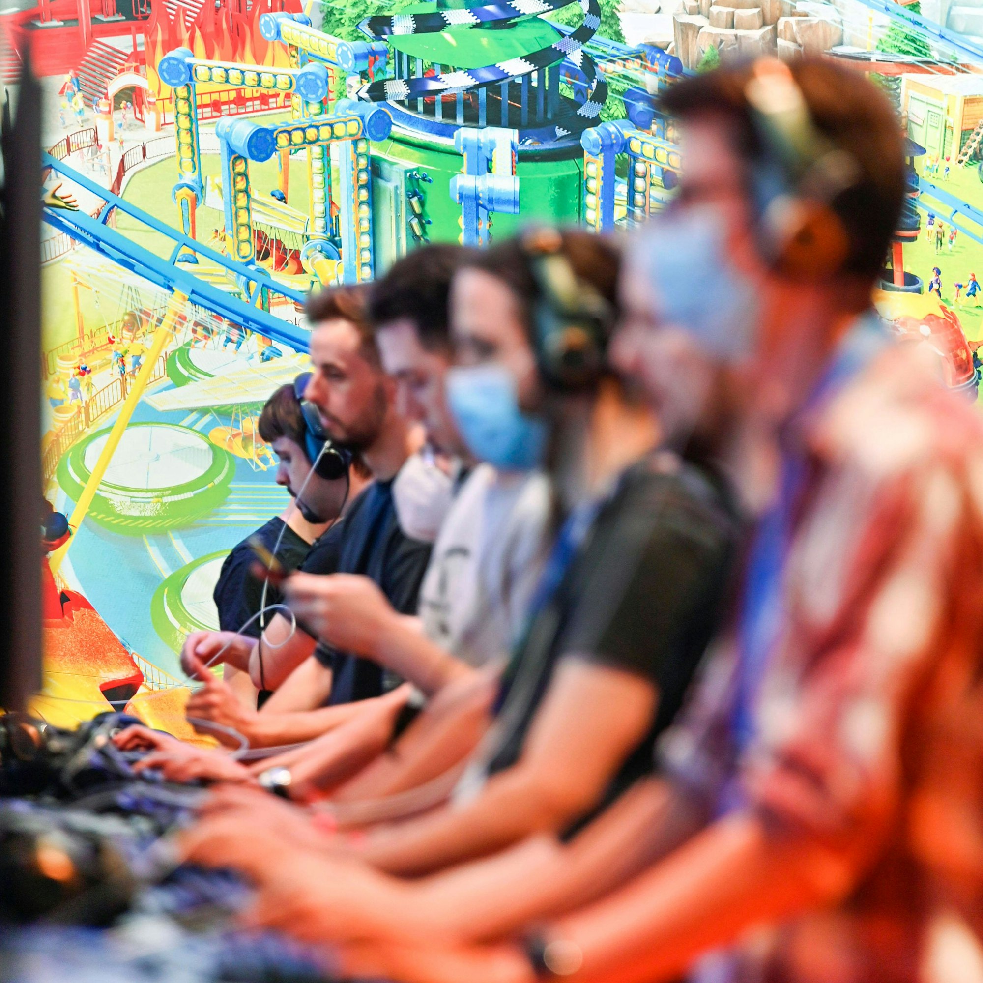Gamer auf der Gamescom 2022 auf dem Gelände der Kölnmesse. Zu sehen sind Gamer vor Konsolen.