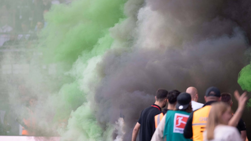 Die Borussia-Fans im Bochumer Gästeblock zünden Rauchbomben während des Spiels.