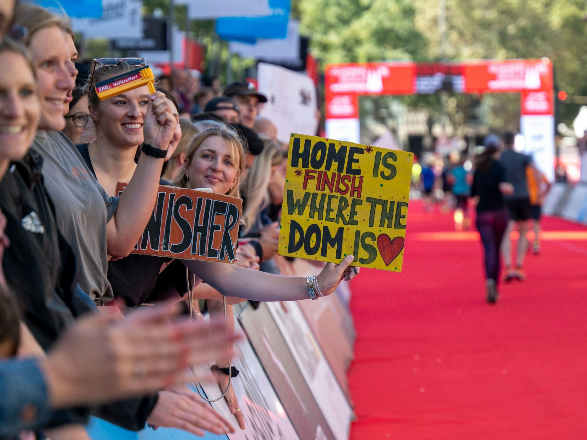 Eine Zuschauerin hält ein Plakat mit der Aufschrift „Home is where the Dom is“.