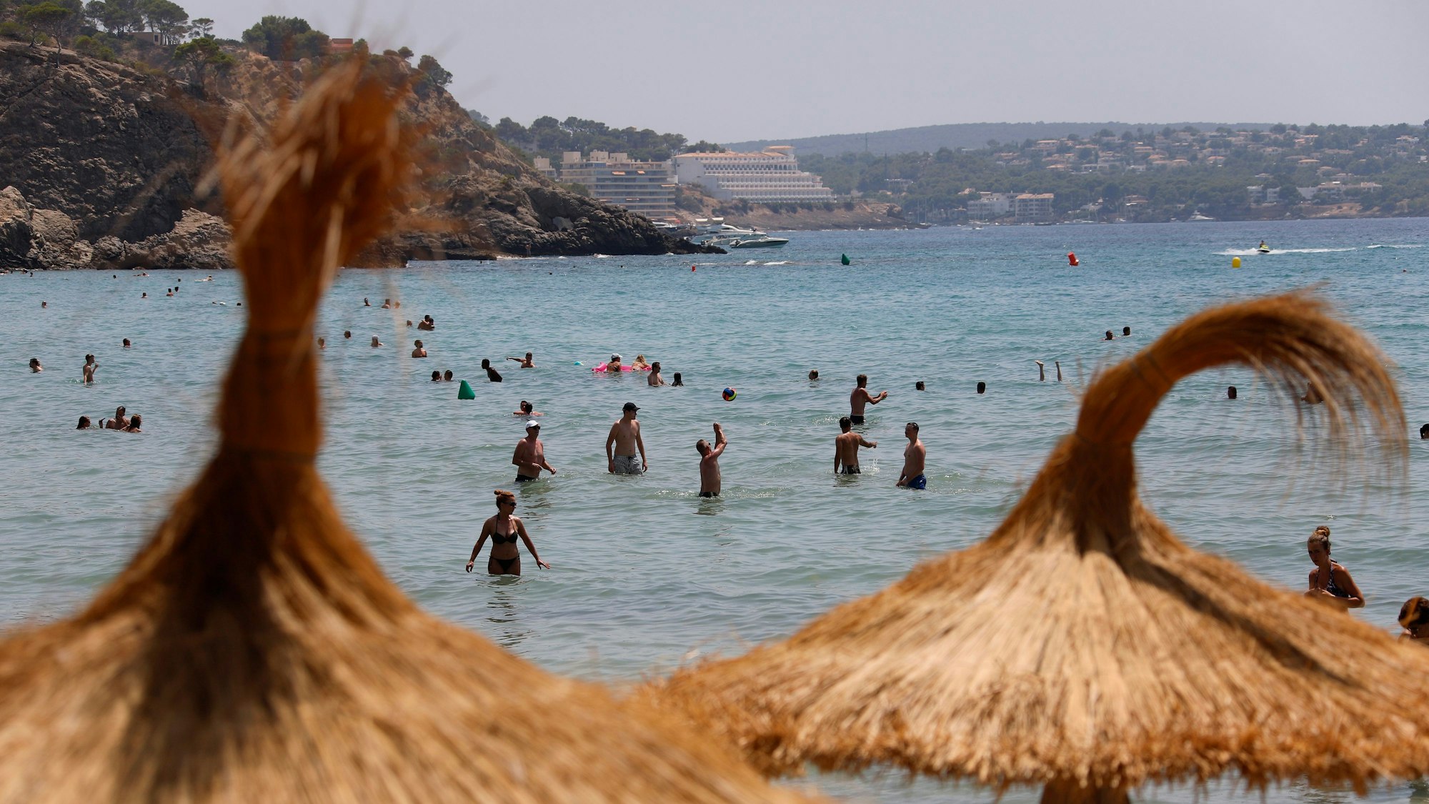 Urlauber erfrischen sich am Stand auf der Insel Mallorca im Meer.