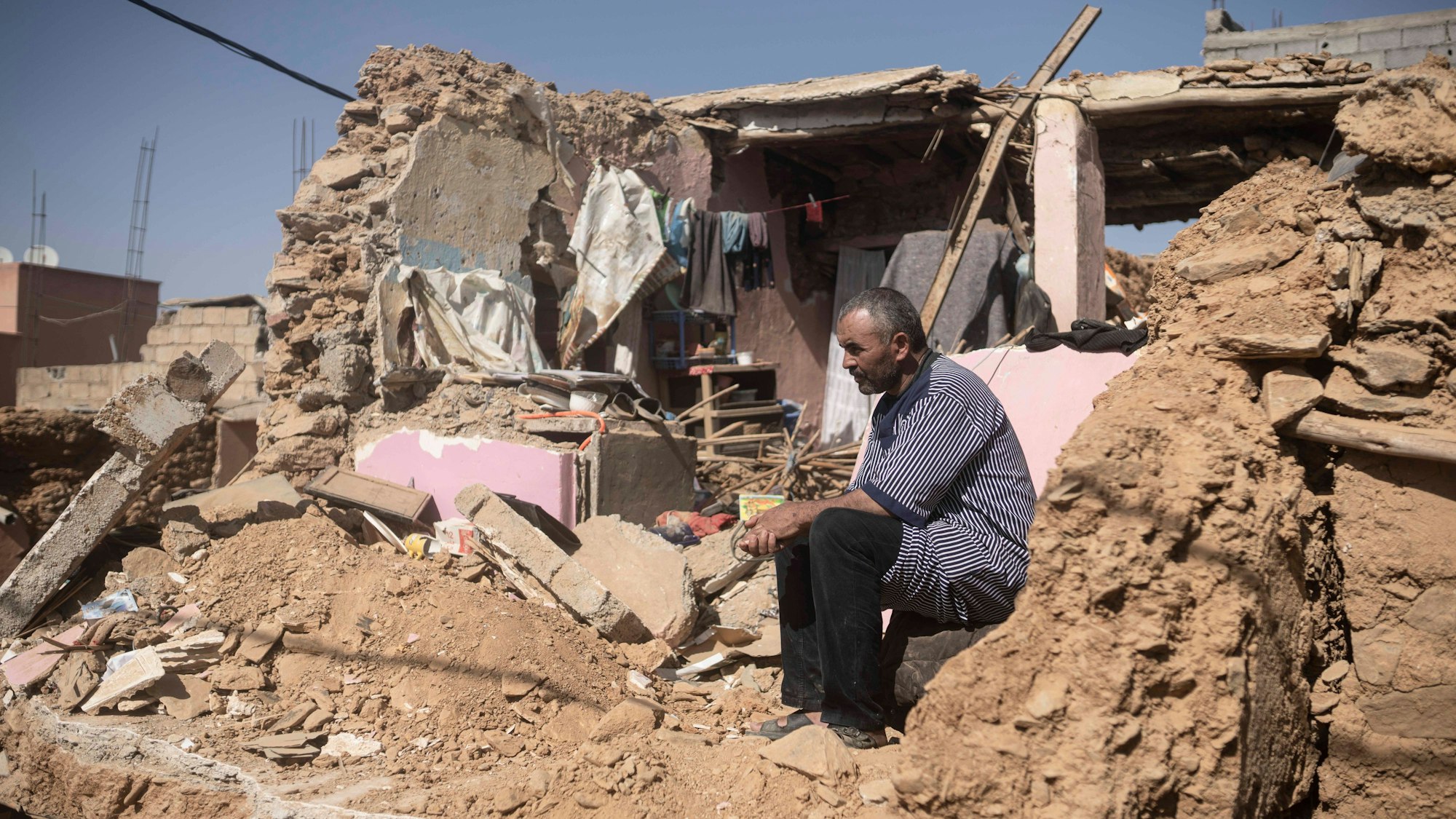 Ein Mann, der seine Frau und seine Tochter bei dem Erdbeben verloren hat, sitzt in seinem ehemaligen Haus in der Stadt Amizmiz außerhalb von Marrakesch.