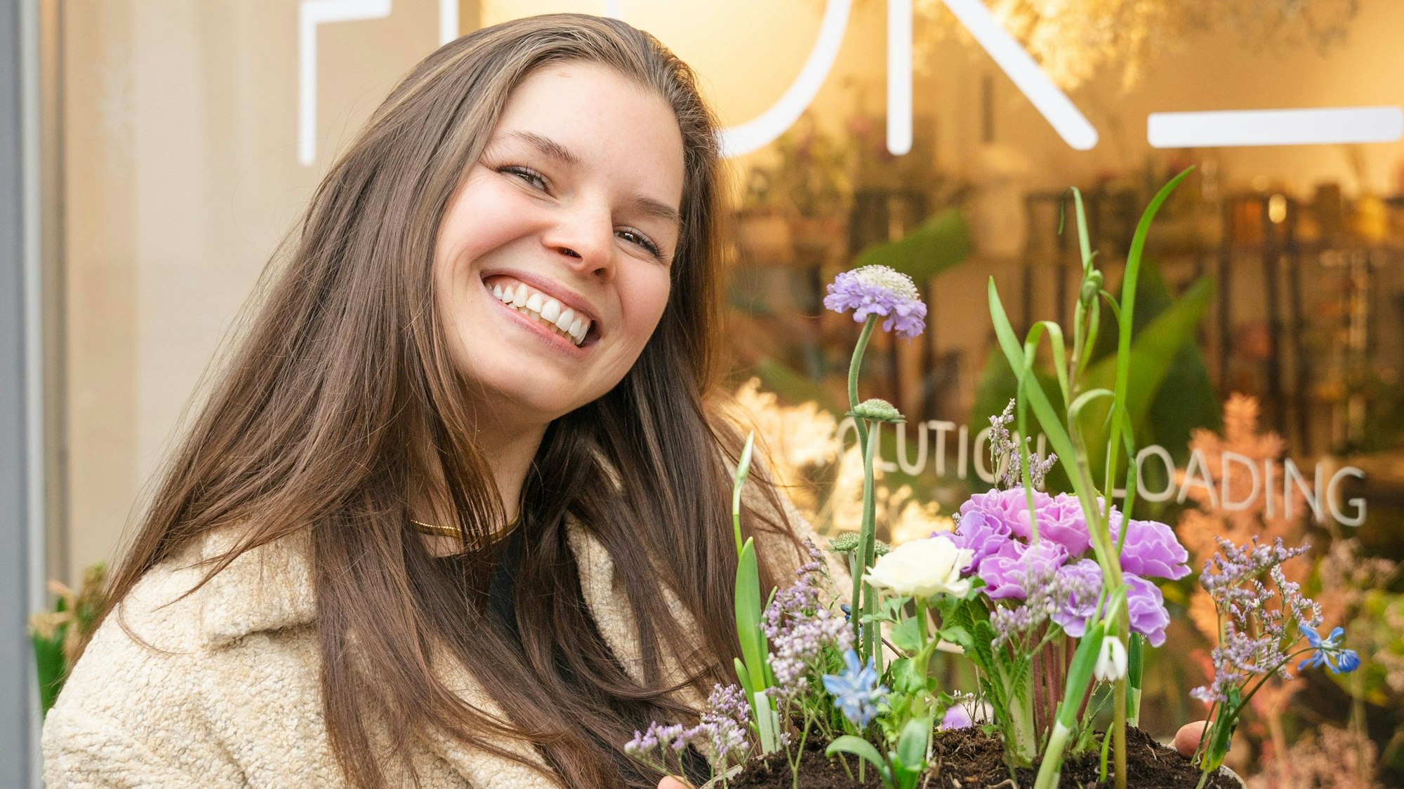Katharina Tesch vor ihrem Laden Florel in Köln-Ehrenfeld mit Blumen in der Hand im Portrait.
