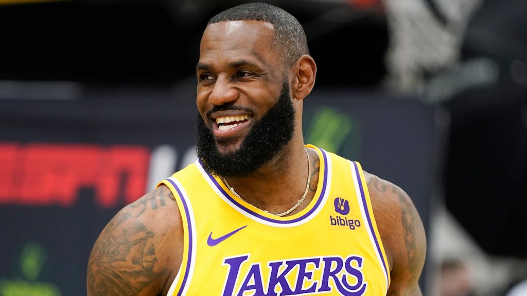 LeBron James grinst beim NBA-Medientag. Er trägt ein gelbes Lakers-Trikot.