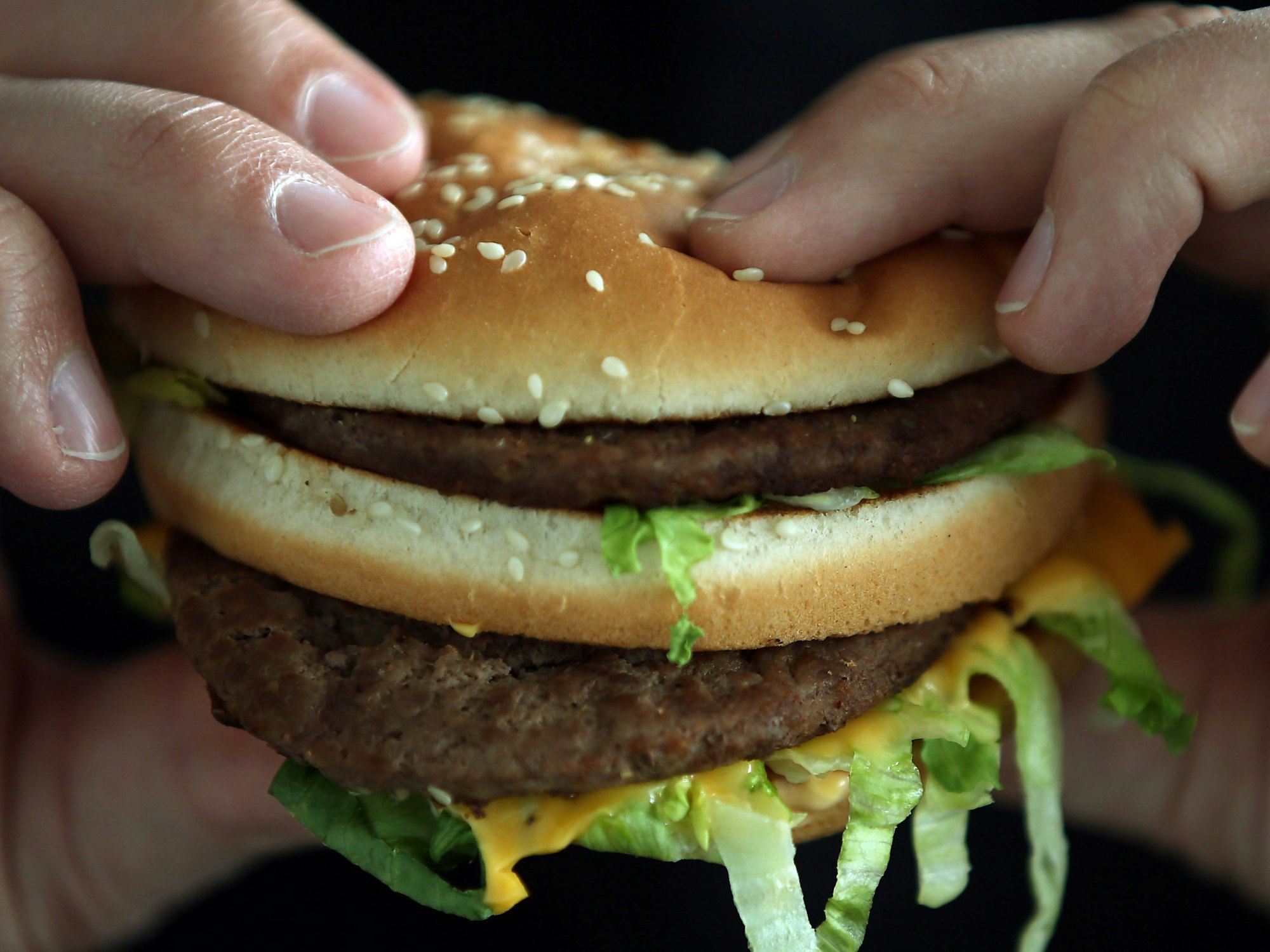Ein Mann beißt in einen Big Mac von McDonald's.