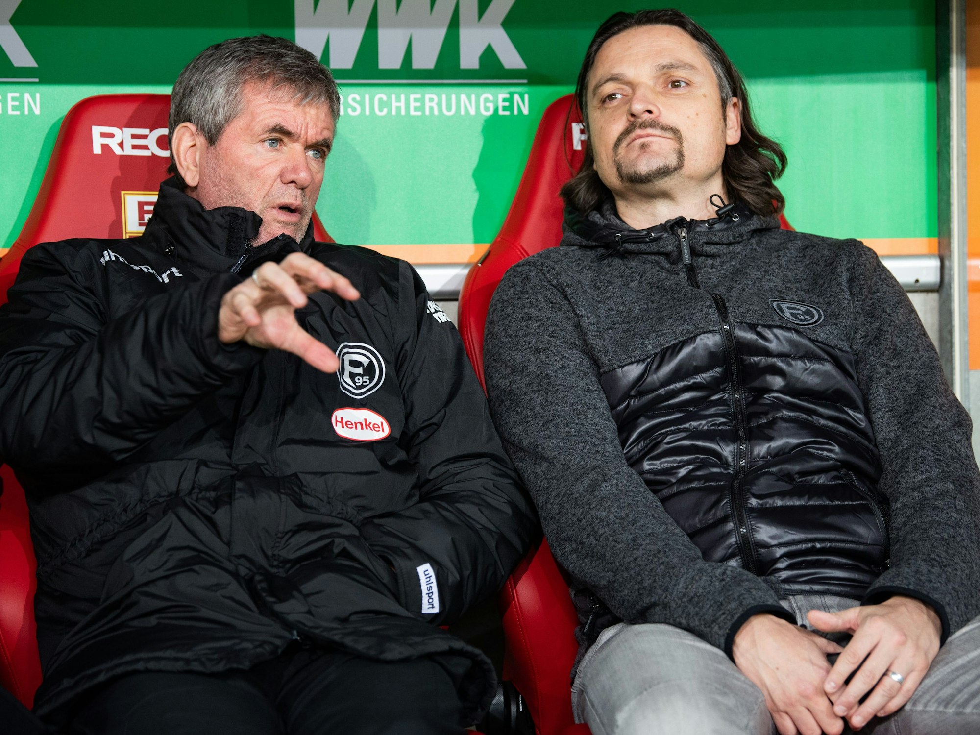 Trainer Friedhelm Funkel von Fortuna Düsseldorf sitzt vor dem Spiel zusammen mit Sportvorstand Lutz Pfannenstiel auf der Trainerbank.
