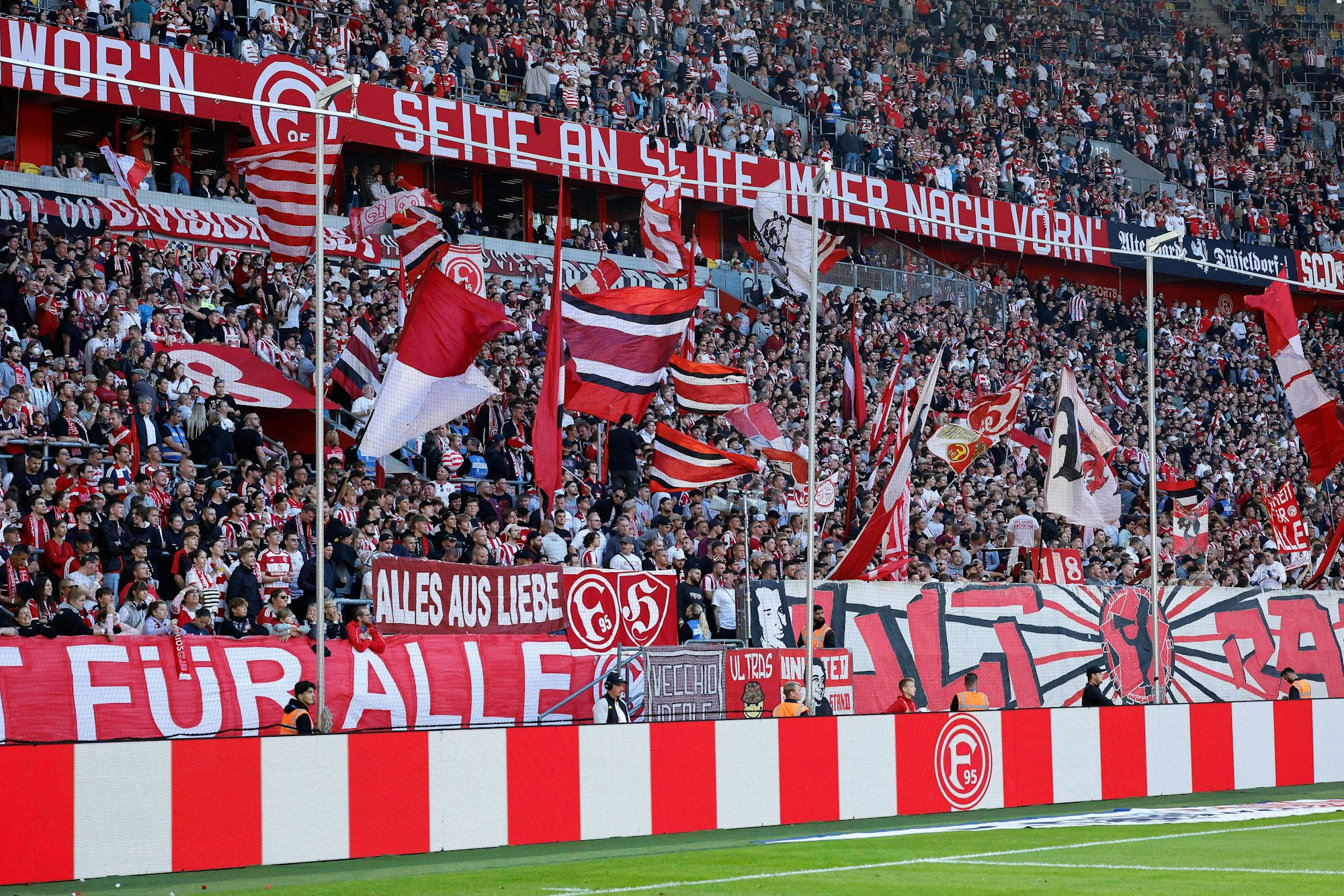 Fans von Fortuna Düsseldorf schwenken beim Heimspiel in der 2. Bundesliga gegen Hannover 96 ihre Fahnen.