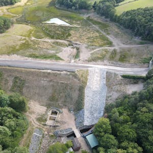 Das Bild zeigt die Steinbachtalsperre aus der Luft. Im Damm ist weiterhin ein großes Loch zu erkennen.