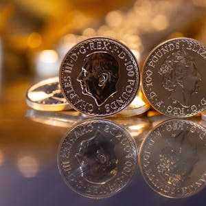 Goldbarren und Goldmünzen in unterschiedlicher Größe liegen beim Edelmetallhändler Pro Aurum in einem Tresor auf einem Tisch.&nbsp;