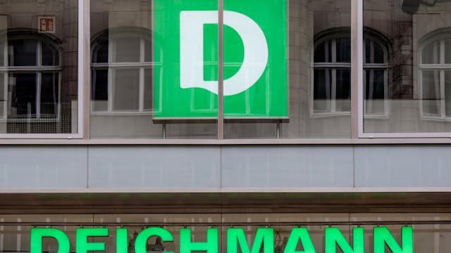 Das Logo der Schuhkette Deichmann hängt über dem Eingang einer Filiale.