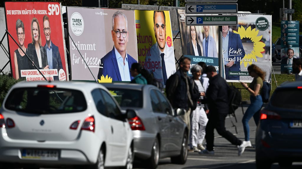 Wahlplakate der Spitzenkandidaten Nancy Faeser (SPD, l-r), Bundesinnenministerin, Tarek Al-Wazir (Bündnis 90/Die Grünen), und Stefan Naas (FDP) stehen an einer Kreuzung am Hauptbahnhof