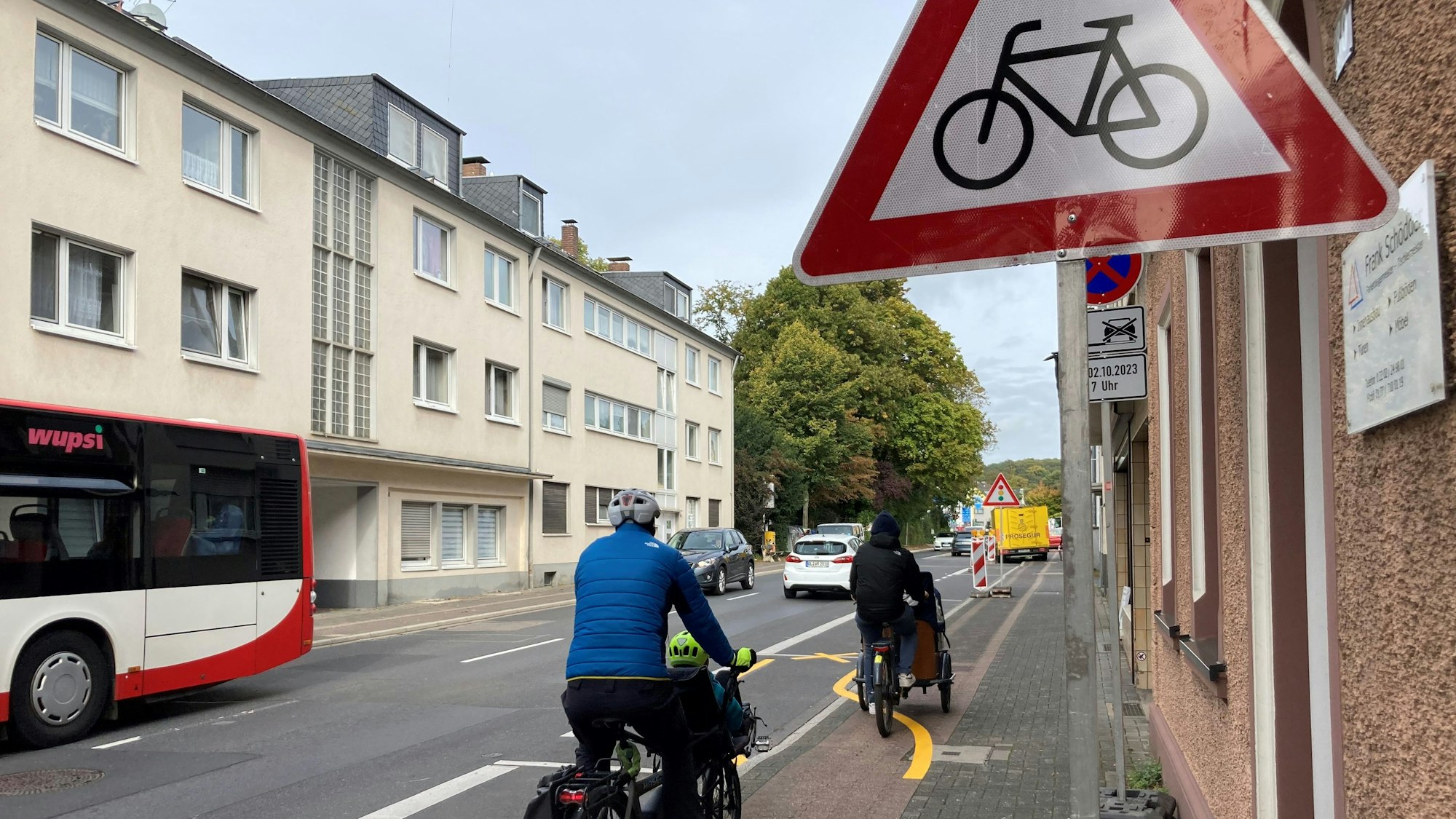 Zu sehen sind zwei hintereinander fahrende Radfahrer, die die gelben für sie ausgewiesenen Markierungen überfahren, um auf dem Radwegbleiben zu können.