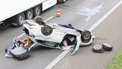 Ein Auto liegt nach einem Unfall auf der Autobahn auf dem Dach auf der rechten Fahrbahn.
