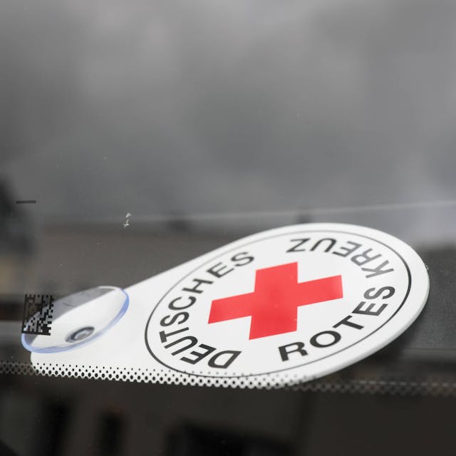 Autoschild Deutsches Rotes Kreuz liegt hinter der Frontscheibe eines Fahrzeuges des Katastrophenschutzes.