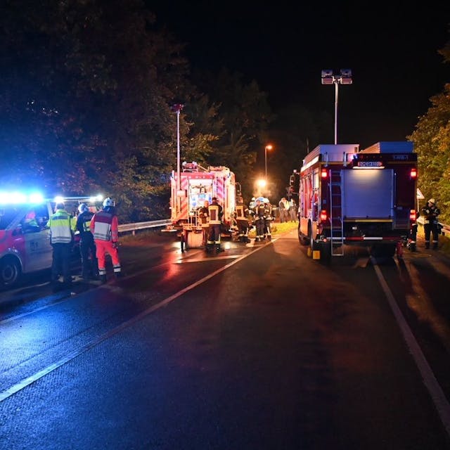 Auf einer Straße sind Rettungskräfte nach einem Unfall nachts im Einsatz.