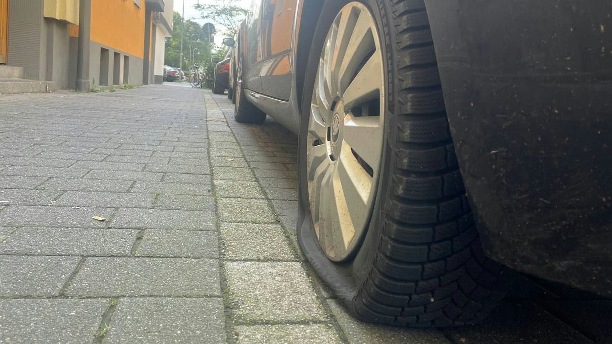 Parkendes Auto mit einem zerstochenen Reifen