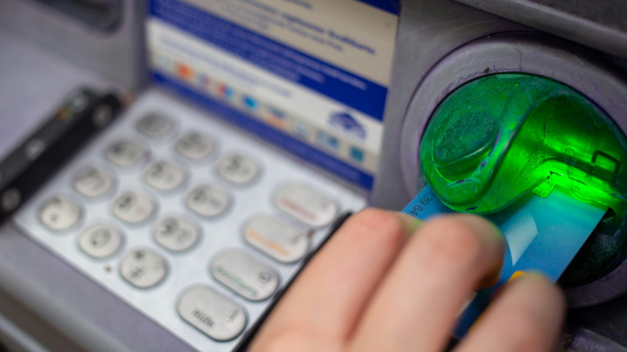 Eine Bankkundin steckt ihre Girokarte in einen Geldautomaten. (Symbolbild)