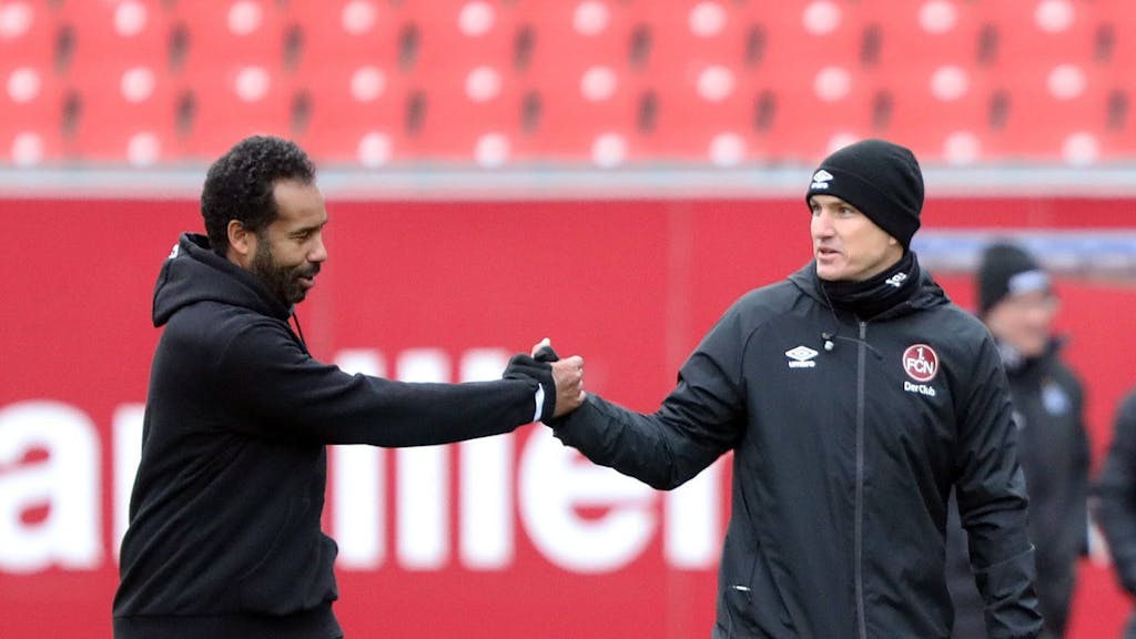 Hamburgs Trainer Daniel Thioune und Nürnbergs Coach Tobias Schweinsteiger klatschen an der Seitenlinie ab.