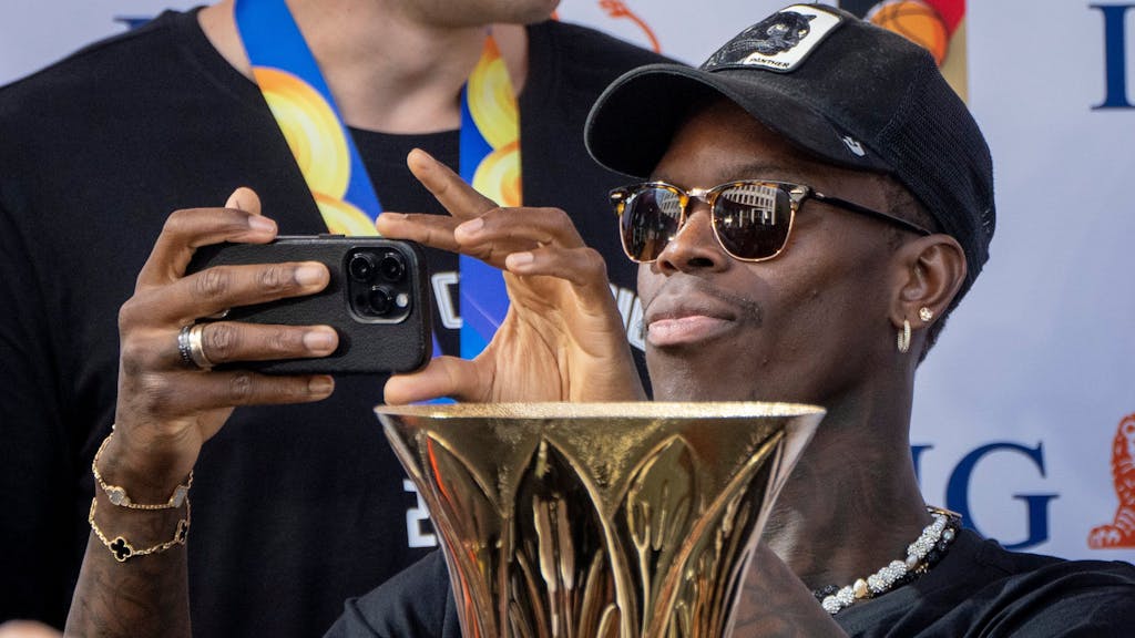 Daniel Schröder macht beim Empfang der Basketball-Weltmeister Bilder mit seinem Smartphone.