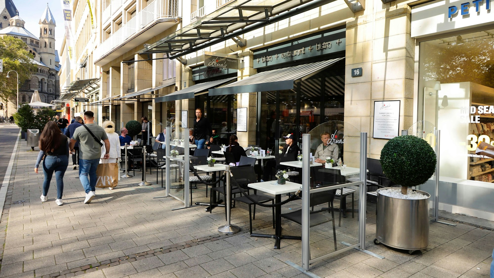 Blick von außen auf das Bistro Diner's am Neumarkt in Köln. Stühle und Tische sind vor dem Lokal aufgebaut.
