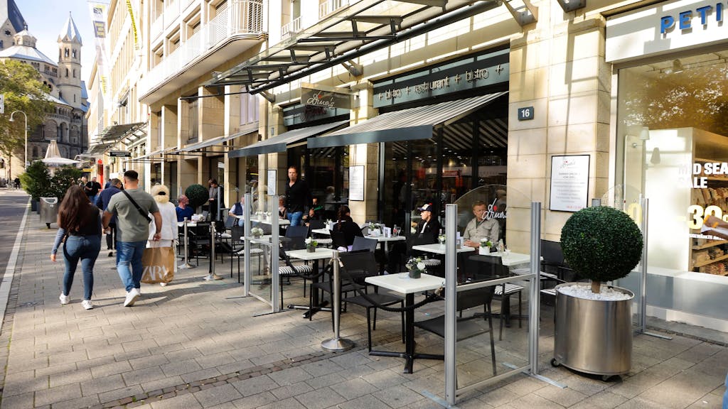 Blick von außen auf das Bistro Diner's am Neumarkt in Köln. Stühle und Tische sind vor dem Lokal aufgebaut.