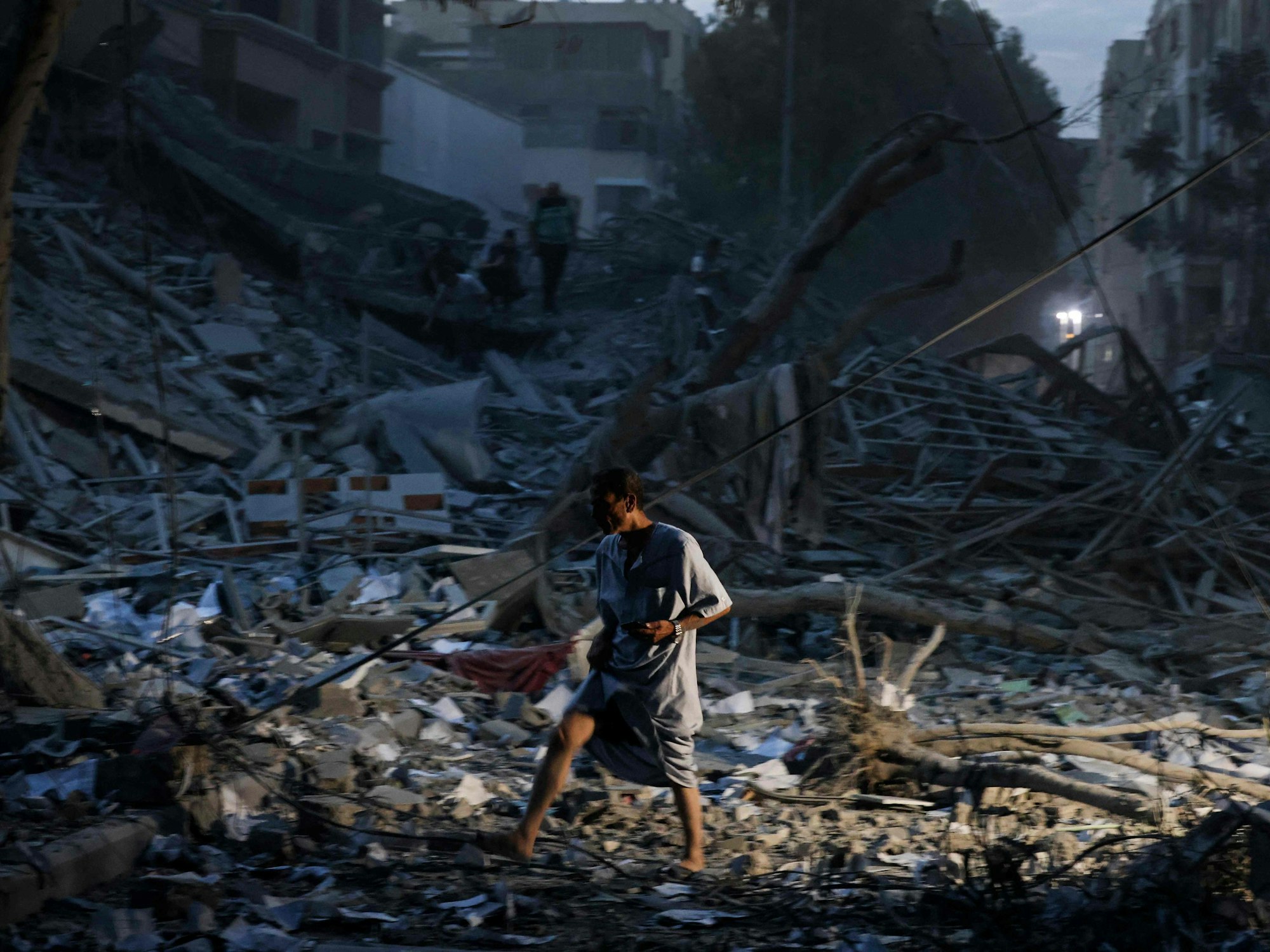 Ein Mann geht auf den Trümmern eines Turms, der am 7. Oktober 2023 bei einem israelischen Luftangriff in Gaza-Stadt zerstört wurde.
