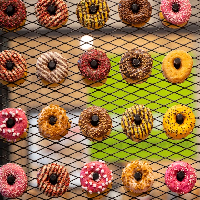 Bunte Donuts sind auf einem Rost ausgestellt