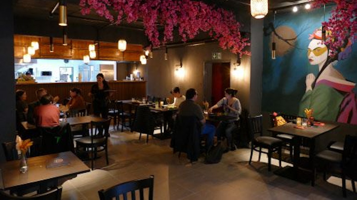 Der Innenraum des Restaurants, mit asiatischen Pflanzen und Gemälden geschmückt.