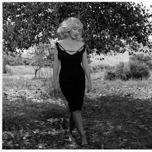 Foto der Schauspielerin Marilyn Monroe, 1960 am Set von „Misfits“. Sie trägt ein enges, schwarzes Kleid.