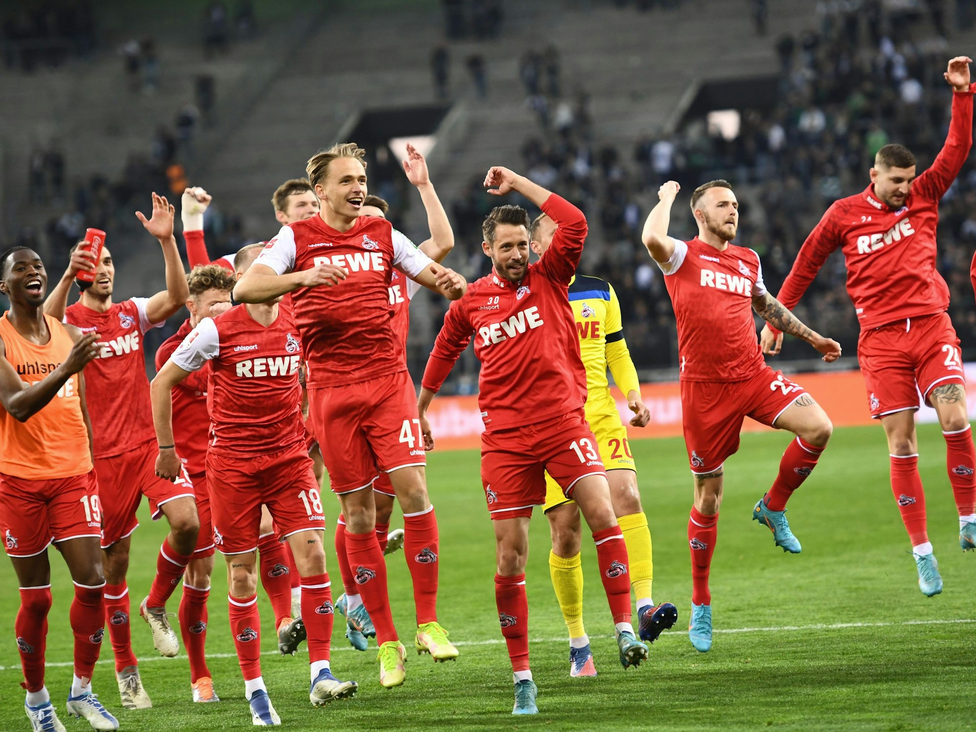 Die Spieler des 1. FC Köln feiern nach einem Derbysieg. Im Vordergrund springen Matthias Olesen und Mark Uth in die Höhe.