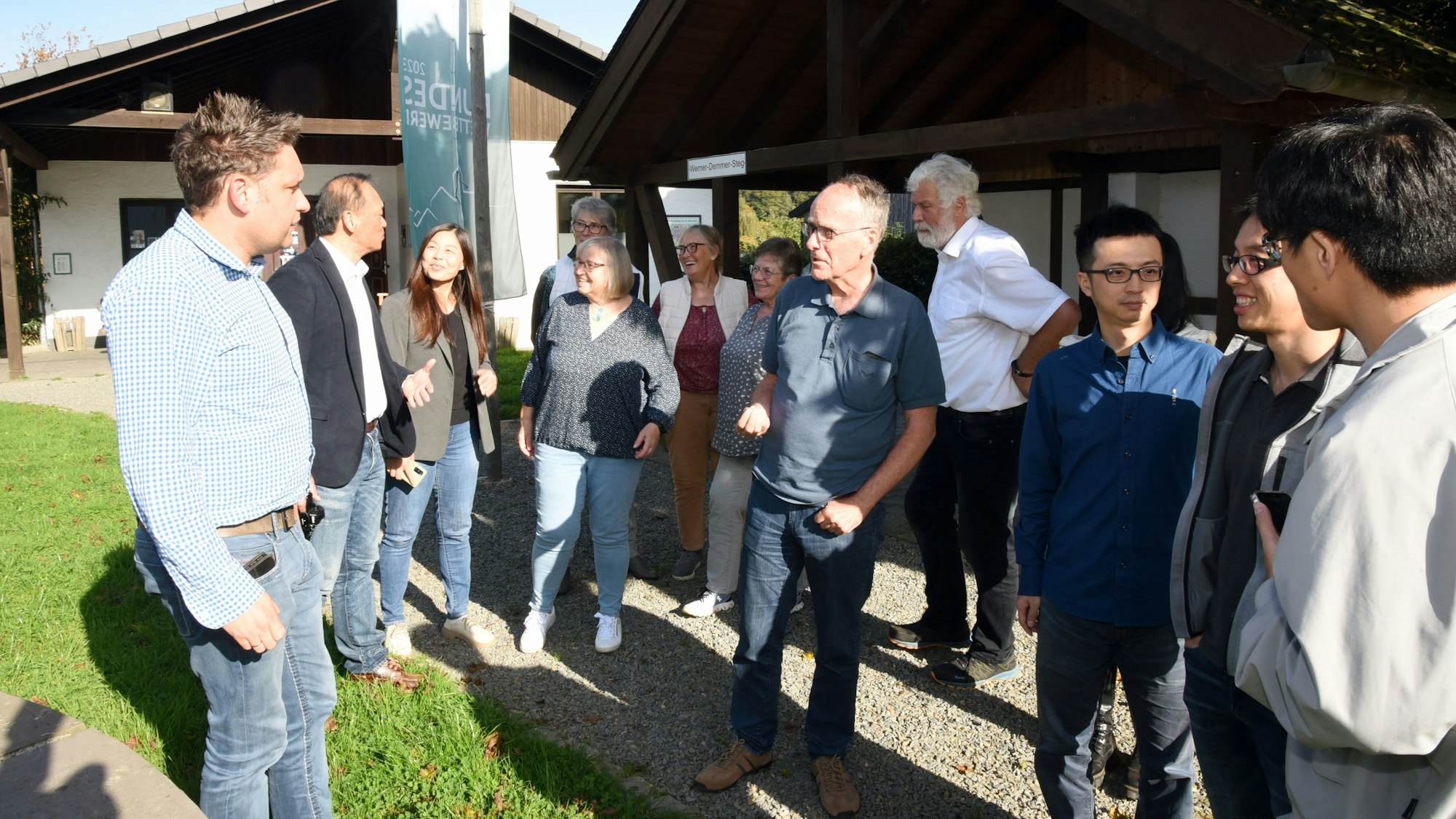 Am Dorfhaus stehen die Gemeinschaft von Benroth und die Delegation aus Taiwan, die sich über die Nutzung „Kalter Nahwärme“ informierte, beisammen.