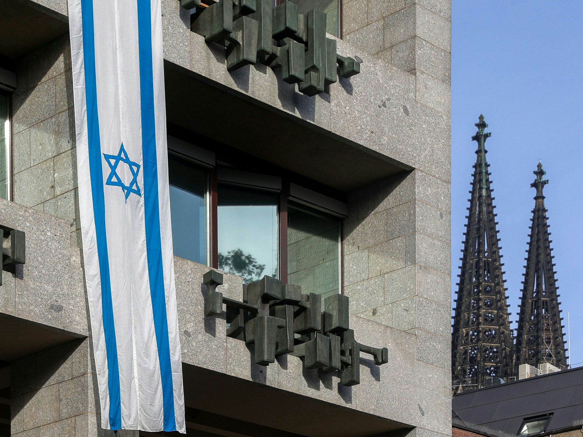 Eine israelische Flagge hängt an der Fassade des Kölner Rathauses.