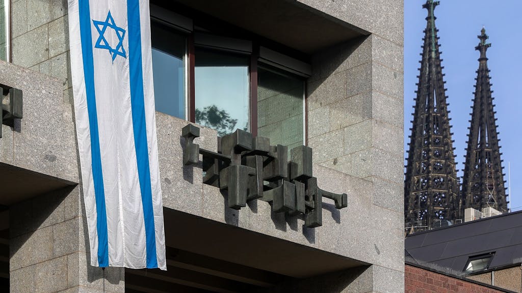 Eine israelische Flagge hängt an der Fassade des Kölner Rathauses.